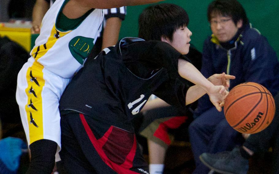 Robert D. Edgren's Khaleem Shabazz defends while a Kamikita guard passes the ball during Saturday's boys high school basketball game at Misawa Air Base, Japan. Edgren won 94-36.