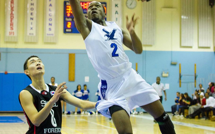 Seoul American's Darien Briggs drives for a layup past Seoul Foreign's Eugene Bang during Saturday's Korean-American Interscholastic Activities Conference Blue Division boys high school basketball game at Yongsan Garrison, South Korea. The Falcons won 70-38 and are now within a win of completing a 12-0 regular season.