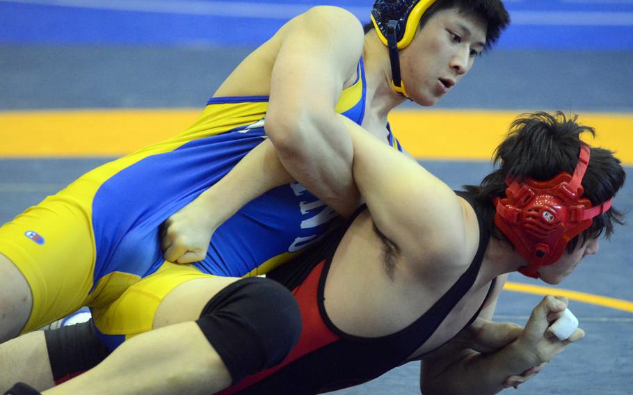 St. Mary's International's Jeff Koo gets the edge on Nile C. Kinnick's Keigo Mull during Saturday's 180-pound bout in the Division I dual-meet final of the 37th Far East High School Wrestling Tournament at Yokota Air Base, Japan. Koo, a three-time Far East champion, won by pin and shared the tournament's Outstanding Wrestler award.