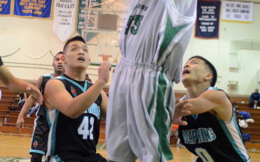 Kubasaki's Matt Ashley skies for the basket between Southern's Kristian Aflleje and Dominic Diego during Monday's pool-play game in the 66th Far East High School Boys Division I Basketball Tournament at Camp Foster, Okinawa. The Dragons won 63-46.