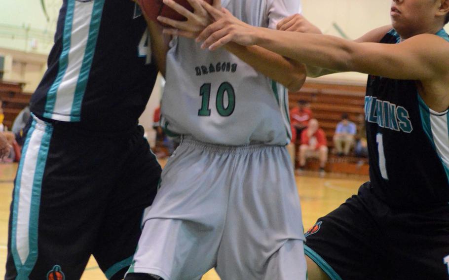 Kubasaki's Imani Washington struggles with the ball between Southern's Kristian Aflleje and Christian Lopez during Monday's pool-play game in the 66th Far East High School Boys Division I Basketball Tournament at Camp Foster, Okinawa. The Dragons won 63-46.