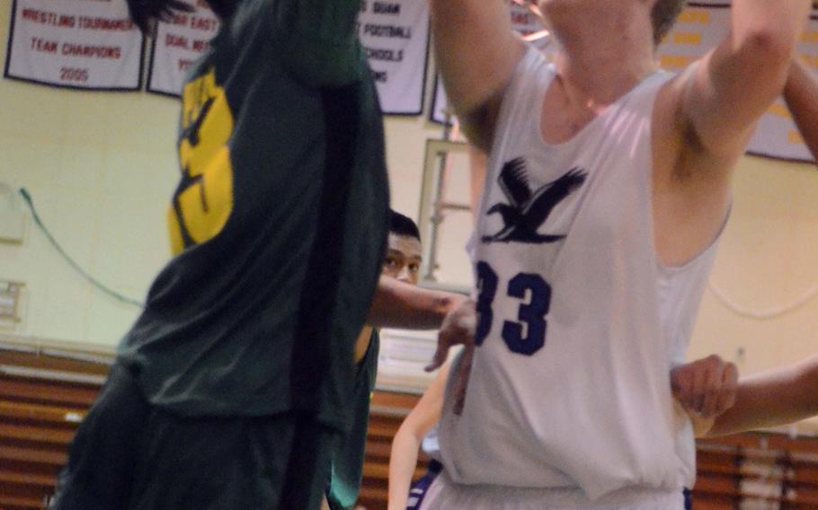 Seoul American's Henry Arnold V tries to shoot against John F. Kennedy's Geno Perez during Tuesday's single-elimination first-round playoff game in the 66th Far East High School Boys Division I Basketball Tournament at Camp Foster, Okinawa.