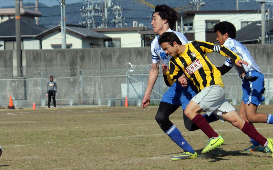Matthew C. Perry's Calvin Barker and Yokota's Chris Beemsterboer chase the ball during Saturday's DODDS Japan high school boys soccer match at Marine Corps Air Station Iwakuni, Japan. Perry won 2-1, and has now won six straight matches after opening 1-2-1.