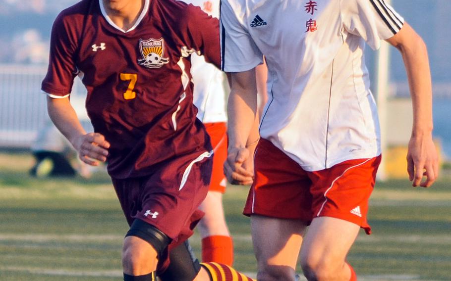 Nile C. Kinnick's Branden Yoder and Matthew C. Perry's Justin Hill give chase for the ball during Friday's DODDS Japan high school boys soccer match at Yokosuka Naval Base, Japan. The Red Devils won 3-1.