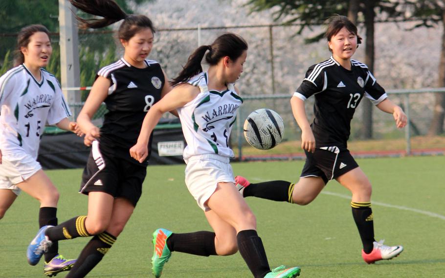 Daegu's Rose O'Houlahan, with ball, is sandwiched by Taejon Christian International defenders Jeehye Lee and Yealin Lim as Daegu teammate Laura Lee looks to help during Wednesday's Korean-American Interscholastic Activities Conference Blue Division high school girls soccer match at Camp Walker, South Korea. The Dragons shut out the Warriors 3-0.
