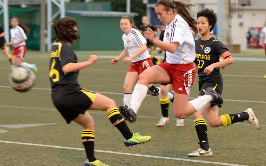Nile C. Kinnick striker Kaile Johnson goes airborne after the ball between American School In Japan's Courtney Ishibashi and Joey Yamada during Wednesday's Kanto Plain Association of Secondary Schools girls soccer match at Yokosuka Naval Base, Japan. The Red Devils won 3-1, handing the Mustangs their first Kanto Plain regular-season loss since a 1-0 defeat on May 11, 2012.