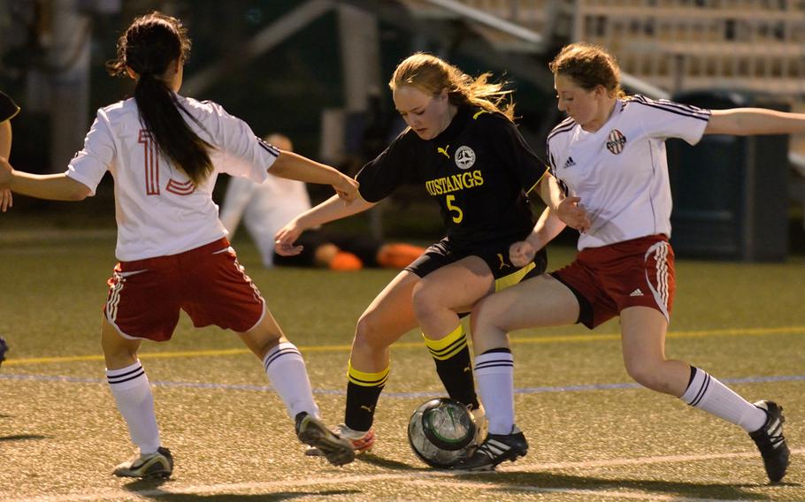 American School In Japan's Heidi Dumesich gets sandwiched between Nile C. Kinnick's Alyssa Arredondo and Alyssa Leal during Wednesday's Kanto Plain Association of Secondary Schools girls soccer match at Yokosuka Naval Base, Japan. The Red Devils won 3-1, handing the Mustangs their first Kanto Plain regular-season loss since a 1-0 defeat on May 11, 2012.