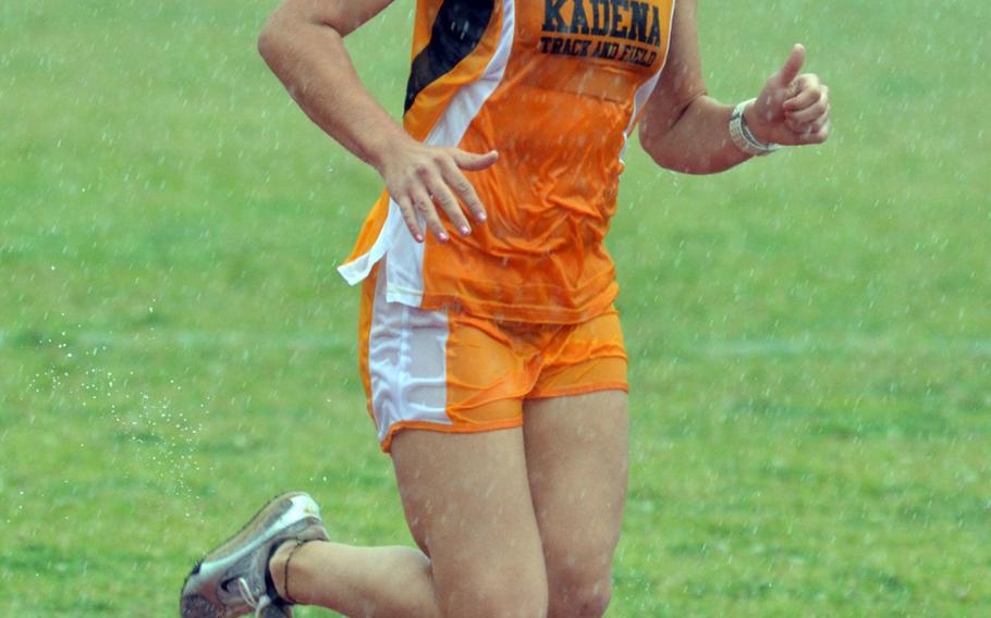 Negotiating her way through a downpour, two-time Far East cross-country champion Ana Hernandez, a Kadena senior, runs the 3,200-meter race during Thursday's first day of the 2nd Oki Relays at  Camp Foster, Okinawa. Freshman Zoe Jarvis of Kubasaki Dragons beat Hernandez in a sprint to the tape, clocking 12 minutes, 55.44 seconds to Hernandez's 12:56.56.