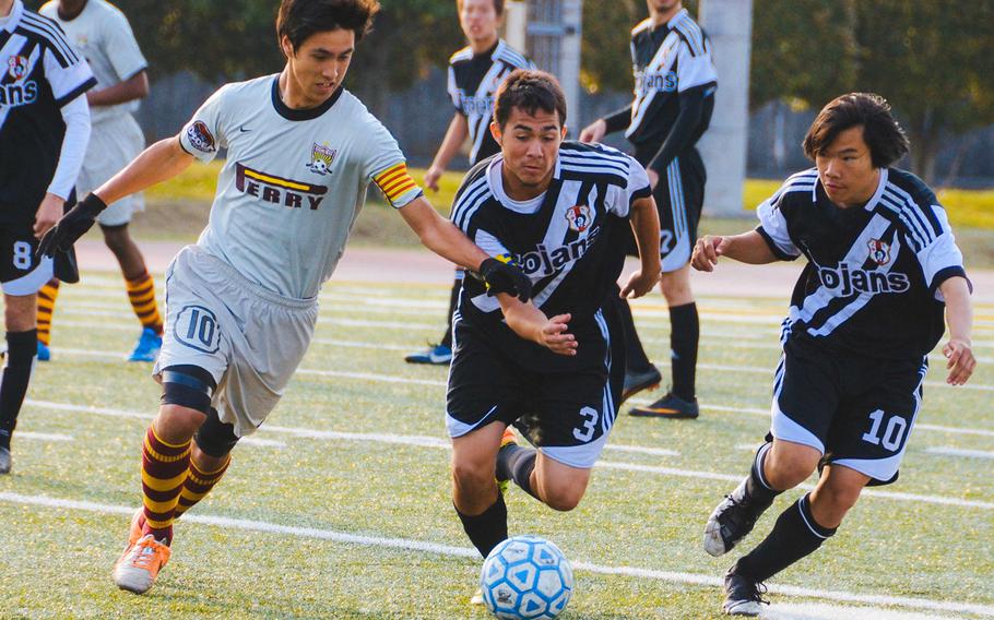Matthew C. Perry's Gaku Lange and Zama teammates Ben Cook and Logan Perera chase the ball during Friday's semifinal match in the DODDS Japan boys high school soccer tournament at Yokota Air Base, Japan. Perry dethroned defending champion Zama 7-1.