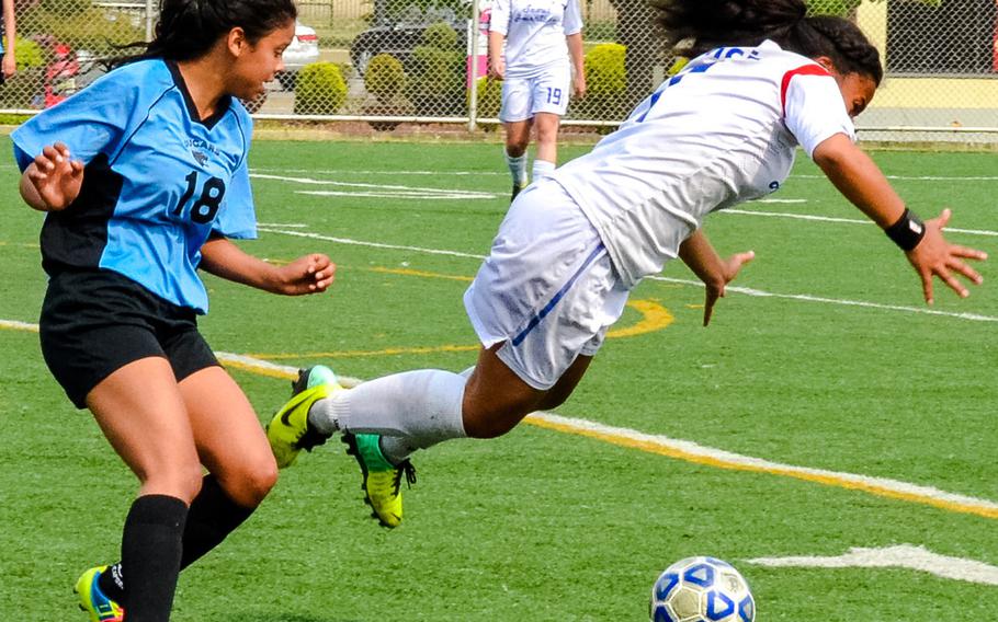 Seoul American's Keisha Runcie tumbles in front of Osan's Bianca Reyes during Saturday's third-placel match in the Korean-American Interscholastic Activities Conference Blue Division high school girls soccer tournament at Yongsan Garrison, South Korea. The Cougars edged the Falcons 3-2.