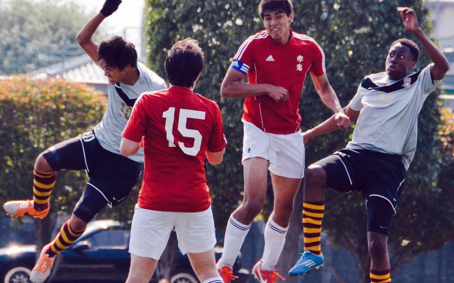 Matthew C. Perry's Gaku Lange and Jarell Davis sandwich Nile C. Kinnick's Dustin Wilson as they go up for the ball in front of Kinnick's Keigo Mull during Saturday's championship match in the DODDS Japan boys high school soccer tournament at Yokota Air Base, Japan. Perry blanked Kinnick 1-0.