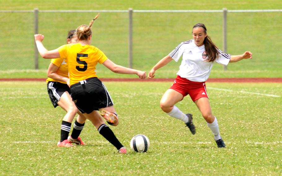 American School In Japan's Heidi Dumesich attempts to move the ball past Nile C. Kinnick's Kaile Johnson during a semi-finals match of the Far East Division I girl's soccer tournament at Camp Foster, Okinawa, May 21, 2014.