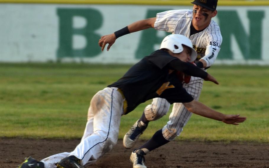 American School In Japan shortstop Tyler Sapsford tags out Kadena baserunner Justin Sego in a rundown during Saturday's Far East Division I baseball tournament final, won by ASIJ 3-0.