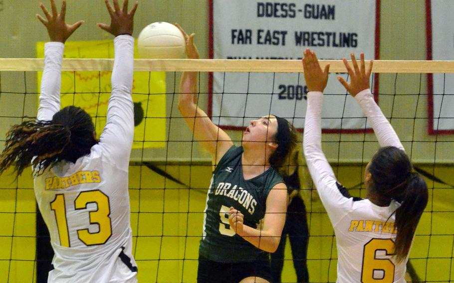 Kubasaki's Kelsey Rogers tries to power the ball past Kadena's Tori Pickens and Ariyanna Chambers during Thursday's volleyball match. The Dragons won 25-15, 25-15, 25-14.