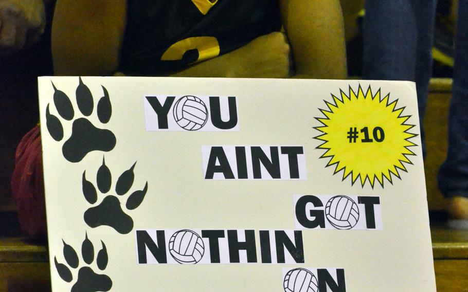 Kadena junior varsity player Rhamsey Wyche holds up a sign supporting her varsity sister Rheagan during Thursday's volleyball match. She probably had good reason for the glum look: Kubasaki won 25-15, 25-15, 25-14.