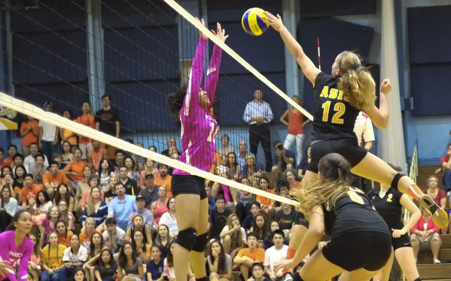 American School In Japan's Mia Weinland goes over the top in a game against rival Nile C. Kinnick on Friday, Oct. 3, 2014,  in Chofu, Japan. ASIJ would win in straight sets 25-17, 25-19, 27-25.