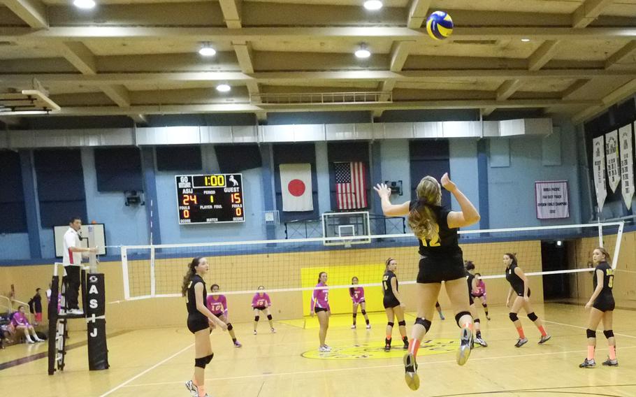 American School In Japan's Mia Weinland leaps for a jump serve in a game against rival Nile C. Kinnick on Friday, Oct. 3, 2014,  in Chofu, Japan. ASIJ would win in straight sets 25-17, 25-19, 27-25.