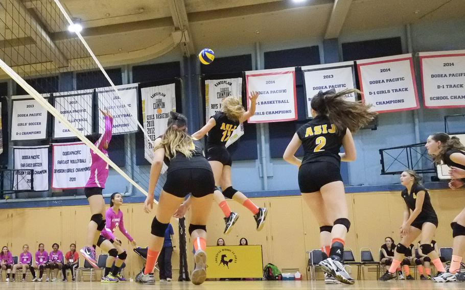 American School In Japan's Mia Weinland leaps for a spike in a game against rival Nile C. Kinnick on Friday, Oct. 3, 2014,  in Chofu, Japan. ASIJ would win in straight sets 25-17, 25-19, 27-25.
