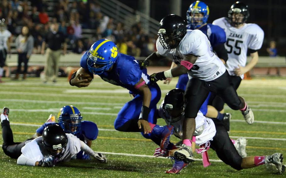 Yokota's Marcus Henagan lunges for the end zone ahead of Zama defenders Jaedon Baker and Curtis Blunt  Friday during a game at Yokota Air Base, Japan. The Panthers won 50-19.
