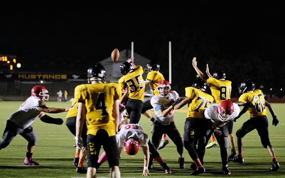 American School In Japan defender Sam Linder gets just enough hand on the ball Friday during an extra point attempt to force the failed conversion in the third quarter of the Mustangs' 15-9 upset over undefeated Nile C. Kinnick in Chofu, Japan.