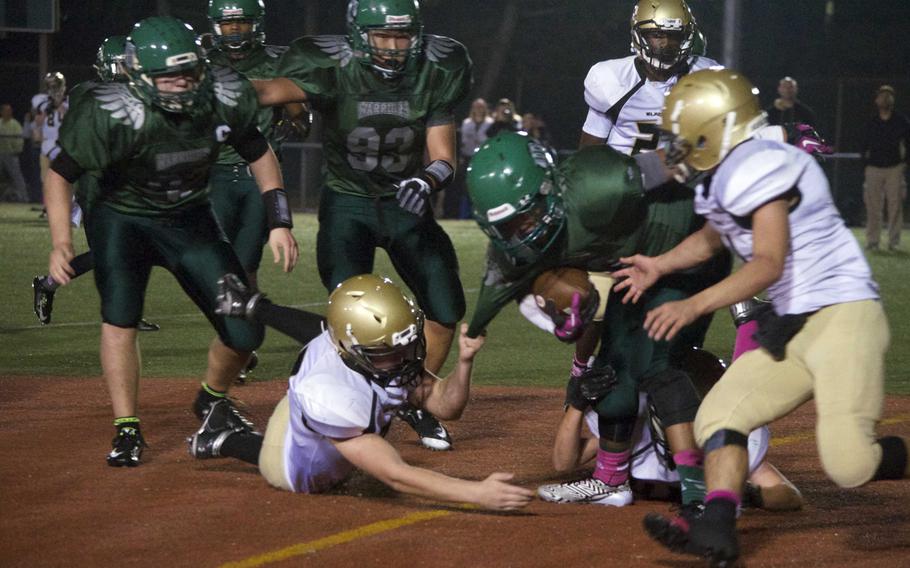 Daegu running back Josh McCaw gets pulled down by his jersey by Humphreys' Stephen Conkright as the Blackhawks' Osie Cruz rushes in to help and Warriors Taylor Mendenhal and Bryon Kim look on Friday at Camp Walker, South Korea.