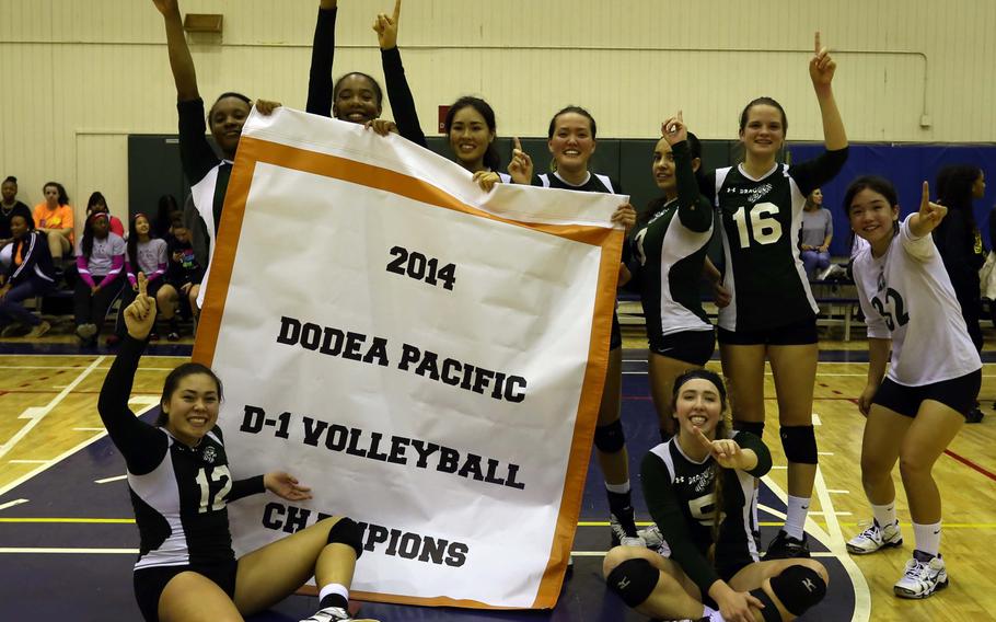Kubasaki players gather round the banner following their championship-match victory over American School In Japan.  Kubasaki won in four sets to capture its first Far East Division I Volleyball Tournament title in school history.