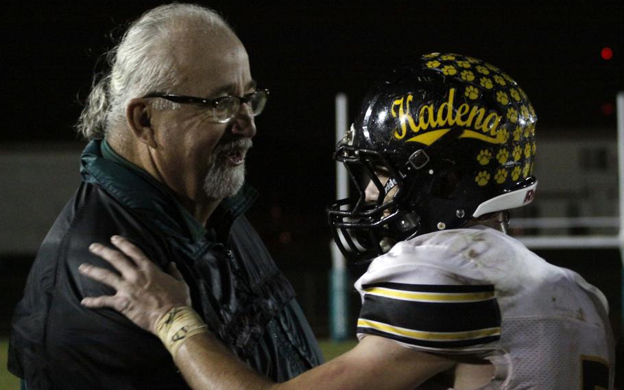 Kubasaki coach Fred Bales congratulates Kadena RB Justin Sego after the Panthers' 41-27 win at the Dragons on Saturday.