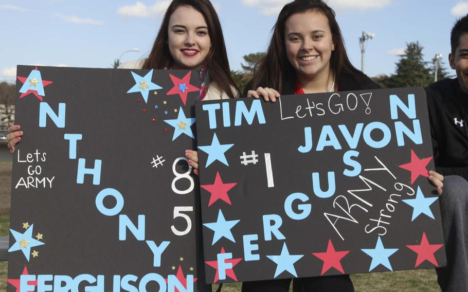 Fans of Army's Anthony and Tim Ferguson brandish signs cheering on their favorites at Saturday's Japan Army-Navy game.