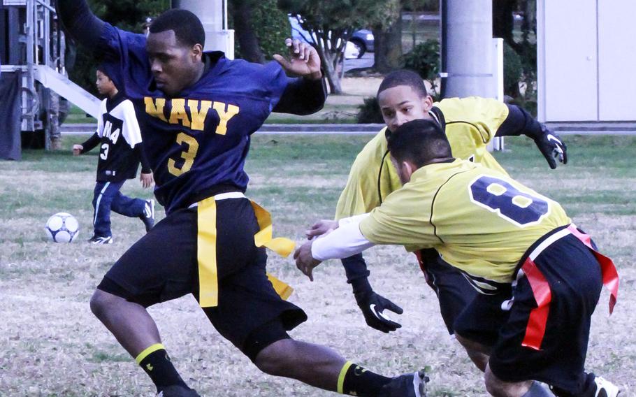 Navy's Terrence Smyre tries to evade Army defenders Juwan Russell and Richard Cabantan  during the Japan Army-Navy game.