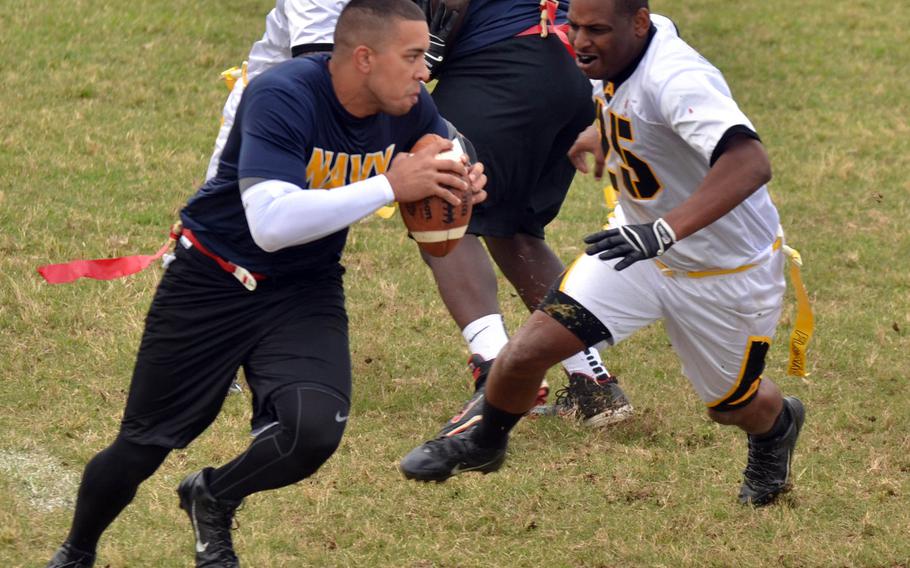 Navy quarterback Rumiel Benson scrambles right to avoid Army defender Desmond Bradley.