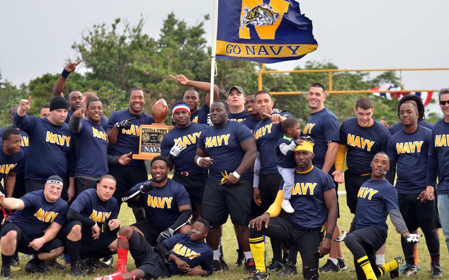 Navy players and coaches celebrate with their newly won Commanders Trophy, their fourth in the last six years.