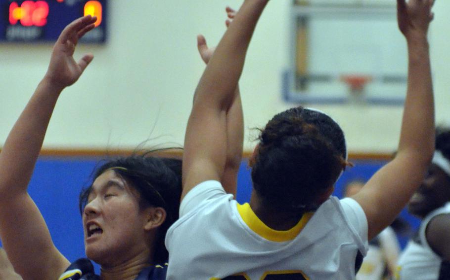 Kitanakagusuku's Anri Motomura and Kadena's Tiarrah Edwards battle for a rebound during Tuesday's high school girls basketball game. Host Kadena routed Kitanaka 102-76, leveling the Panthers' record a 3-3 to close 2014.