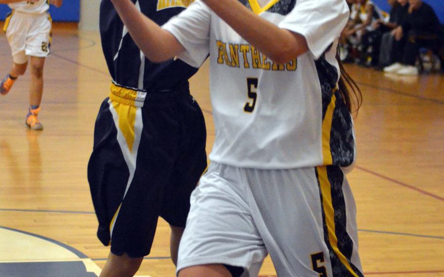 Alicia Vaughan of Kadena drives to the basket against Kitanakagusuku's Hina Aguni during Tuesday's high school girls basketball game. Host Kadena routed Kitanaka 102-76, leveling the Panthers' record a 3-3 to close 2014.