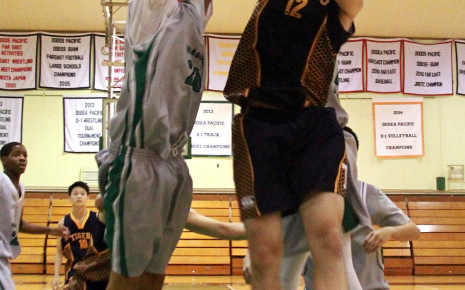 Kubasaki's Skylor Stevens and Taipei American's Riley Chang sky for a rebound during Saturday's interdistrict boys basketball game at Kubasaki.