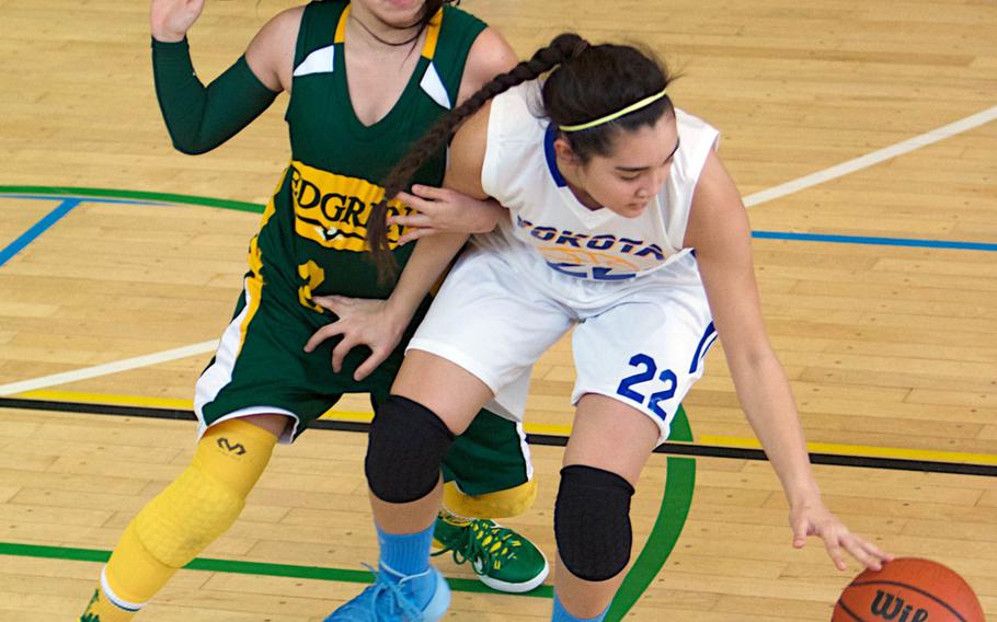 Yokota's Sarah Cronin tries to find the handle on the ball against Robert D. Edgren defender Vanessa Black during Saturday's DODDS Japan basketball game. The Eagles prevailed 39-33.