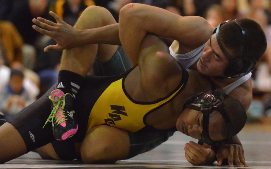 Kubasaki's Jonathan Orr gains the edge on Kadena's Dominique Tate in the 148-pound bout. Orr won by technical fall 20-10 in full time, but the Panthers beat the Dragons 42-22 for their third dual-meet win of the season.