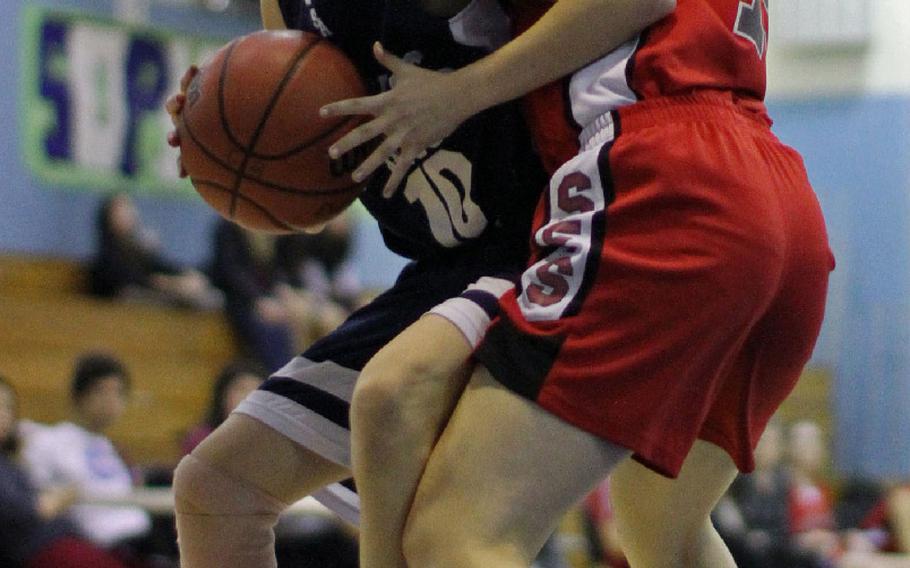 Seoul American's Hannah Frederick tries to drive through Seoul Foreign's Mischa Kim during the Korea girls basketball game, Jan. 24, 2015. The Falcons won 42-34.
