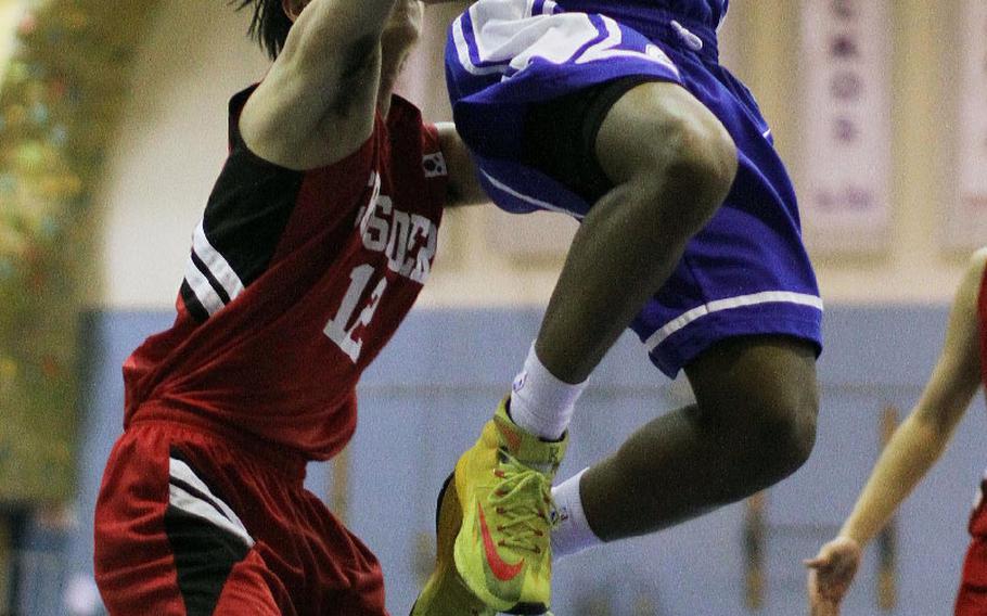 Seoul American's Jez Harper skies for the layup against Seoul Foreign's Brian Park during the Korea boys basketball game, Jan. 24, 2015. The Falcons won 66-44.