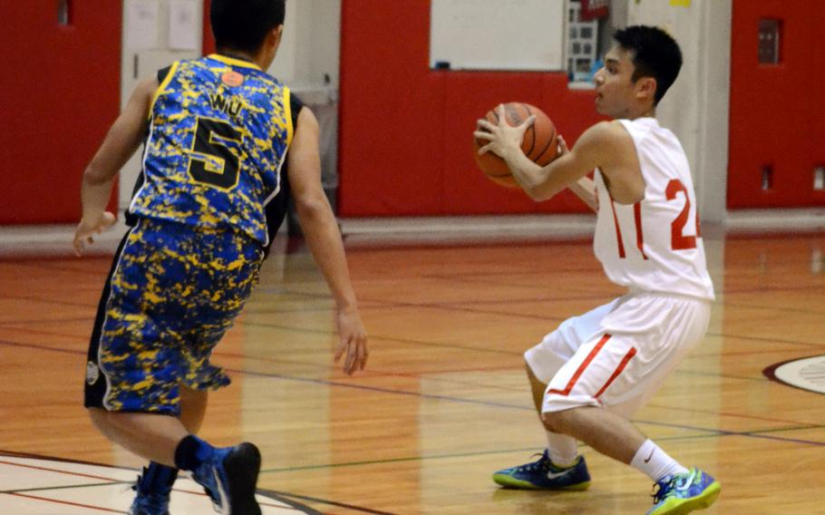 Nile C. Kinnick's James Custodio looks for operating room against St. Mary's International's Likai Wu during Kanto Plain boys basketball game, won by the Titans 63-42, on Monday, Jan. 26, 2015.