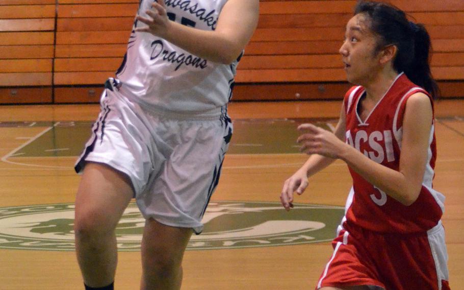 Kubasaki's Jessica Ramirez goes up for a shot past Okinawa Christian's Ryubi Miyagi during Saturday's Okinawa girls basketball game. The host Dragons won 52-24.