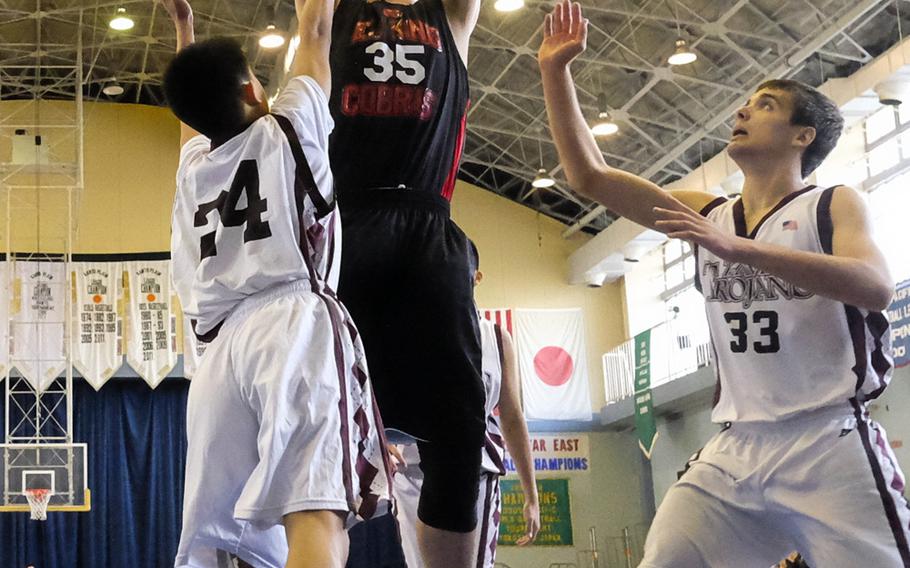 E.J. King's Jacob Lyle pulls up for a short jumper over Zama's Colin Gomez during bracket play of the DODDS Japan Basketball Tournament on Friday at Yokota Air Base, Japan. King would lose the game 64-43.