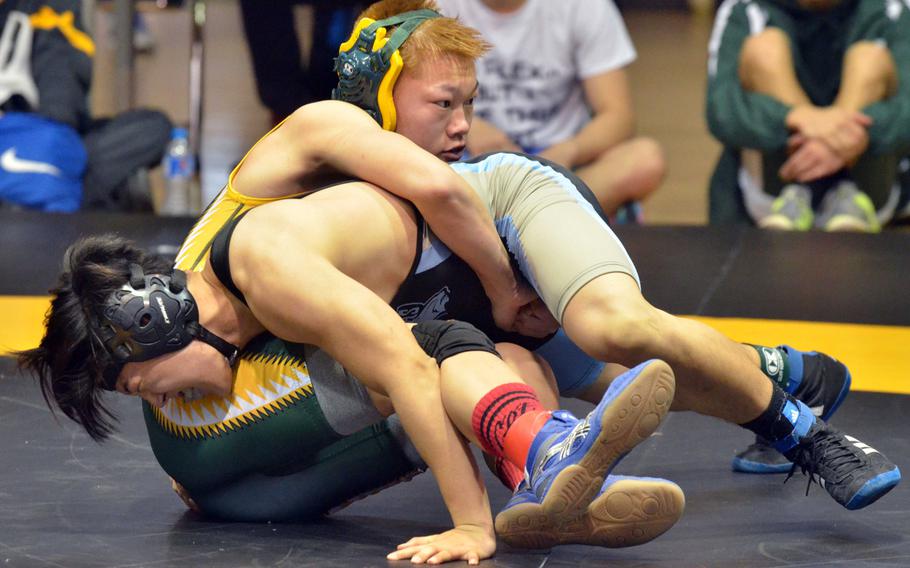 Robert D. Edgren's Kade Sundvall performs a leg lift on Osan's Sam Kim in the 122-pound bout during Saturday's Far East tournament Division II dual-meet final. Sundvall decisioned Kim 15-12, a result that preceded five straight Eagles pins to put the meet out of reach. Edgren won 46-16.