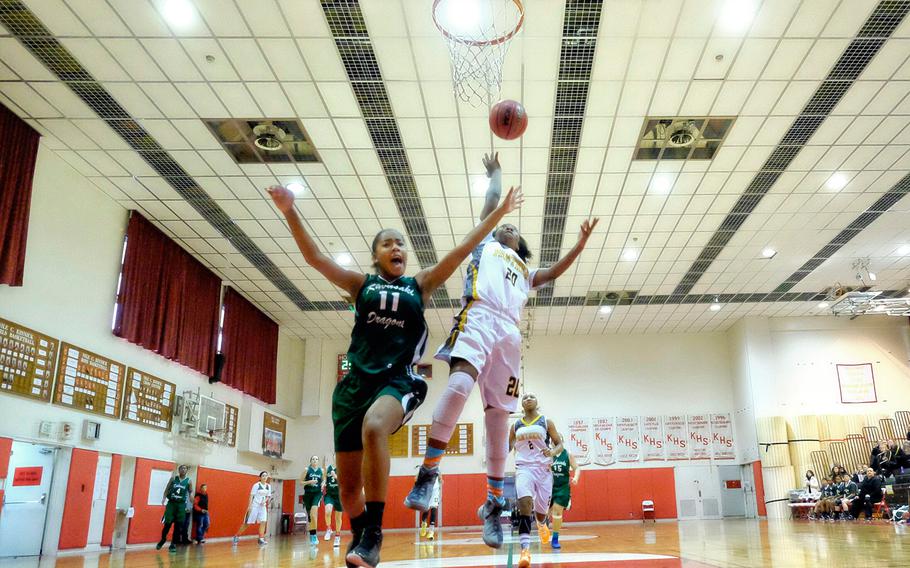 Kadena's Brenda Gulley finishes a fast break as Kubasaki's Josie Daffin overruns the play during the 2nd semifinal of the Division I girls Far East basketball tournament Wednesday, Feb. 18, 2015, at Yokosuka Naval Base, Japan. Kadena defeated Kubasaki 54-27 and went on to play American School in Japan for the championship. 