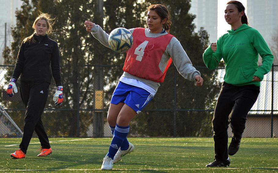 Seoul American defender Kayla Granado fields the ball between teammates Charley Smith and Lizzy Puskas during Wednesday's practice.