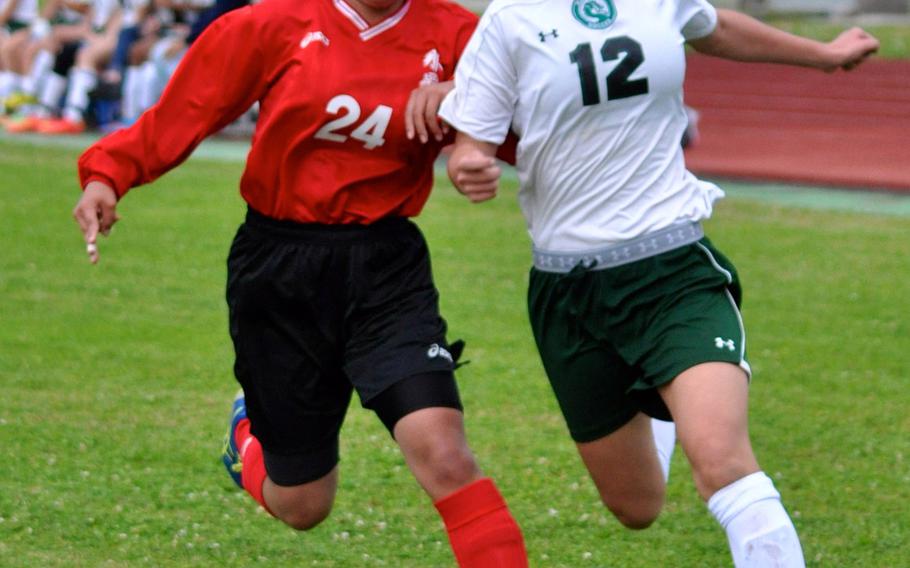 Kubasaki striker Ami Eldridge tries to beat a Naha Nishi defender to the balll during Saturday's season-opening match for the reigning Far East Division I Tournament champion Dragons; they won 2-0.