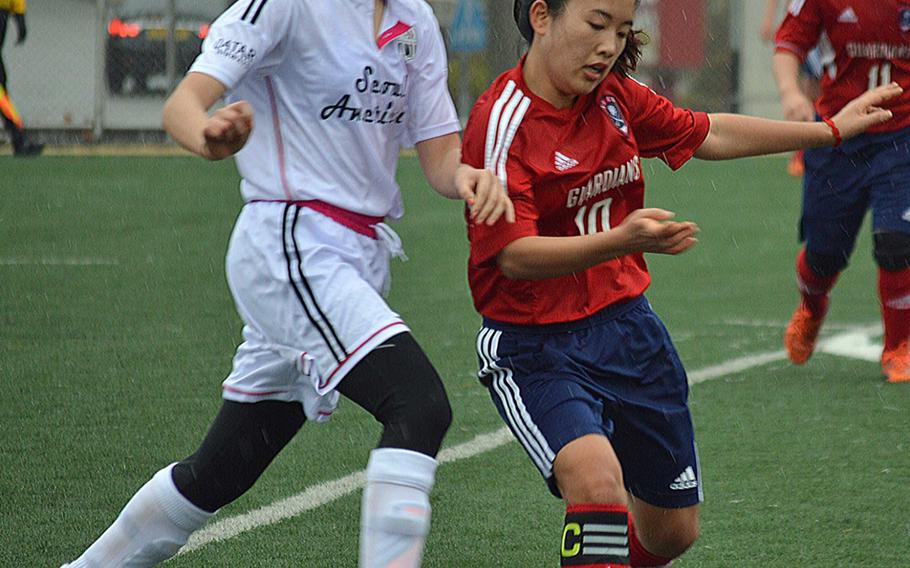 Seoul American's Hannah Frederick and Yongsan's Juhee Kim battle for the ball during Wednesday's Korea girls soccer match, which ended in a 1-1 draw.