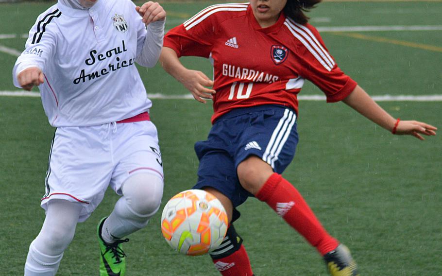 Seoul American's Mariam Sarver and Yongsan's Juhee Kim battle for the ball during Wednesday's Korea girls soccer match, which ended in a 1-1 draw.