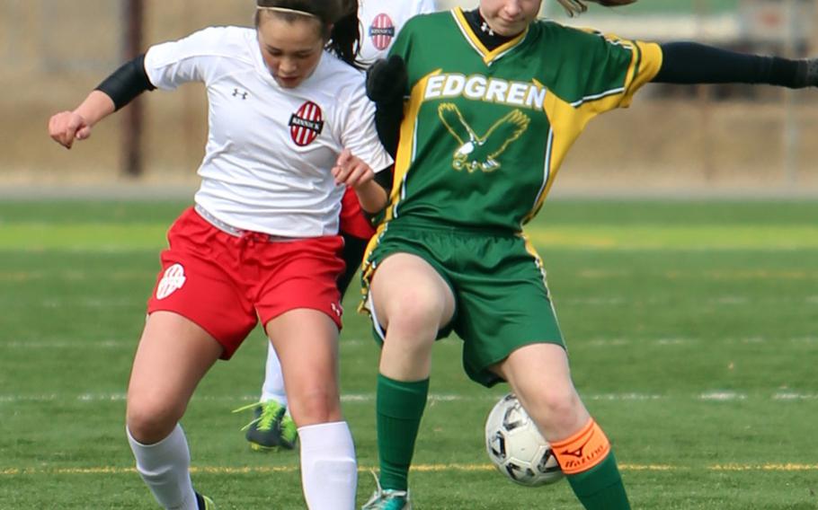 Nile C. Kinnick's Charla Johnson and Robert D. Edgren's Madeline Mattingly battle for the ball during Saturday's DODDS Japan girls soccer match. The Red Devils won 5-0 to sweep the weekend series.