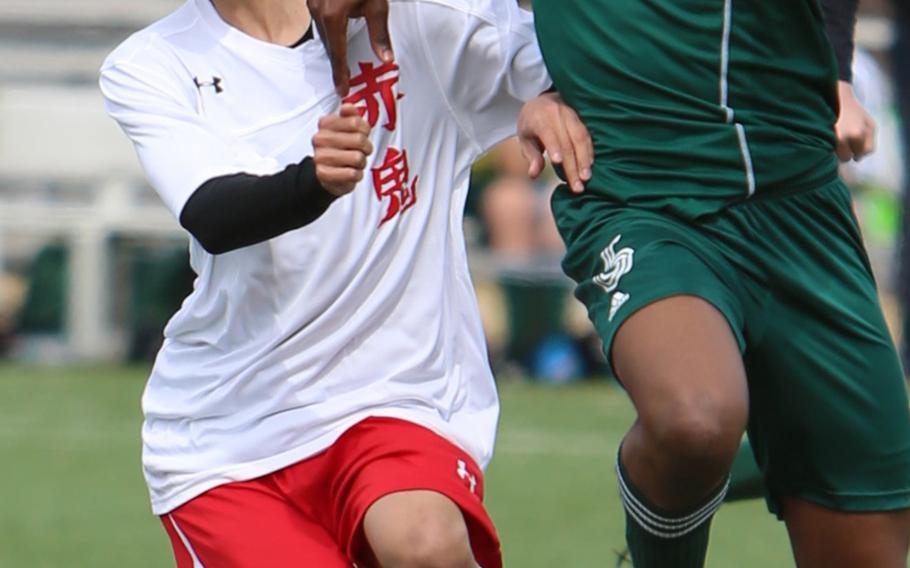 Nile C. Kinnick's Kaito Kobielusz and Robert D. Edgren's Jojo Njorge battle for the ball during Saturday's DODDS Japan girls soccer match. The Red Devils won 5-3 to sweep the weekend series.