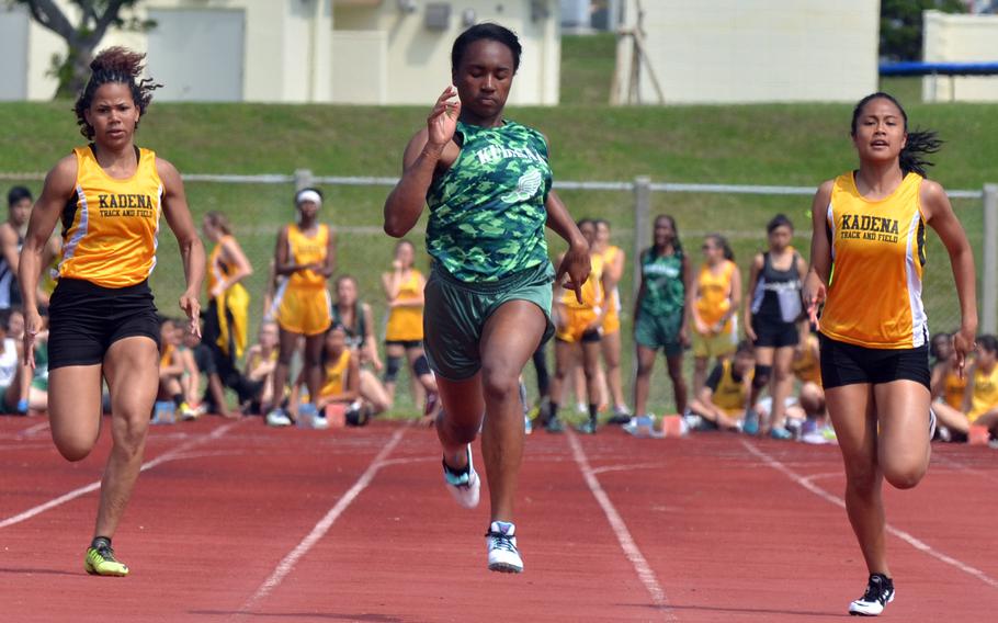 Kubasaki's Kaelyn Francis pounds for the finish, flanked by Kadena's Monet Baker and Apryl-Len Cabase during the girls 100-meter dash in Saturday's Okinawa season-opening track and field meet. Francis clocked 12.02 seconds on the stopwatch, the second-fastest time in Pacific history by any timing method.